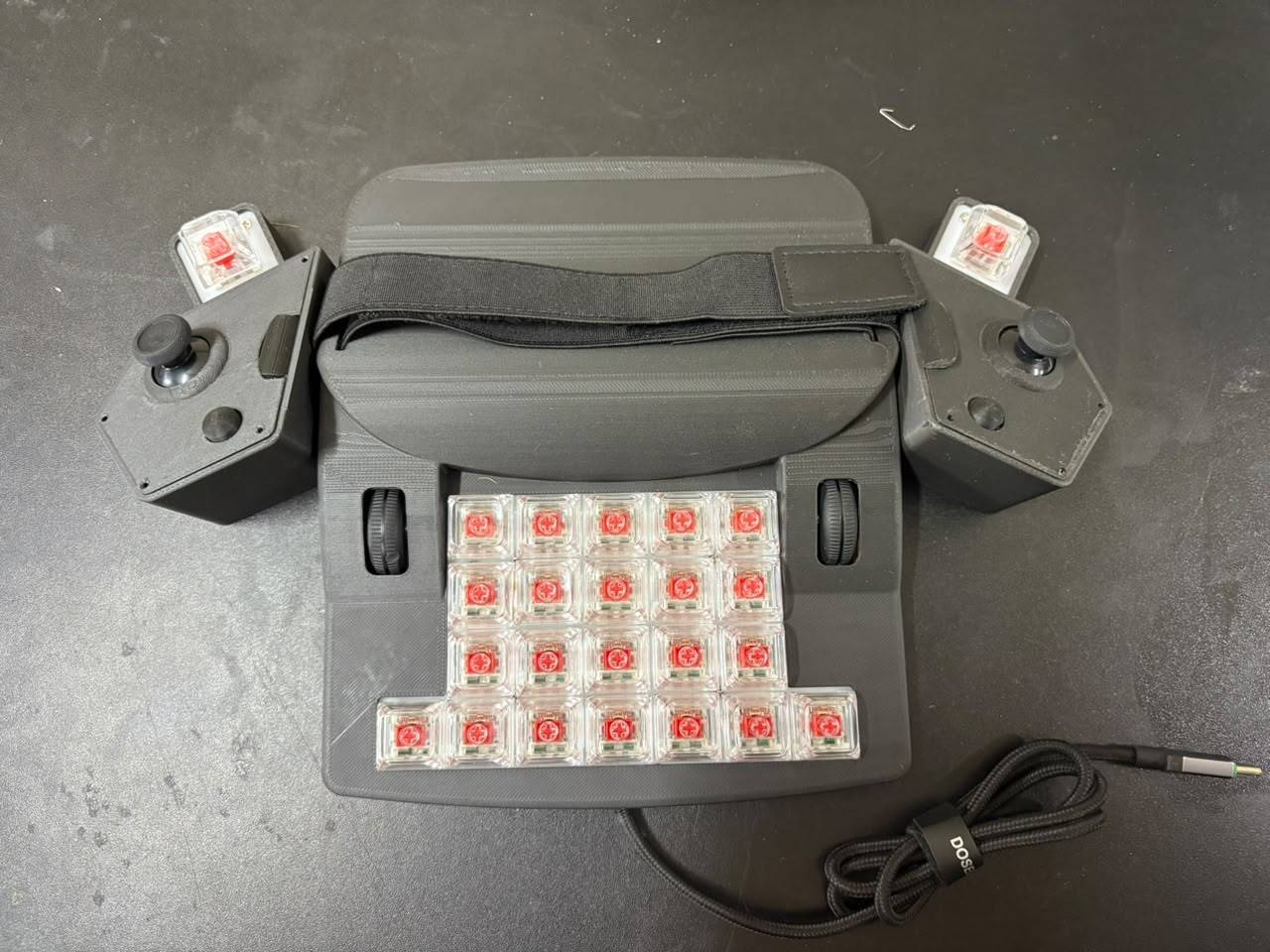Top-down view of the ERCHAM MK1 functional prototype showing the switch layout, palm rest with strap, and left and right thumb clusters